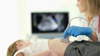 child receiving ultrasound of liver and pancreas from doctor